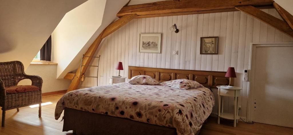 ein Schlafzimmer mit einem großen Bett im Dachgeschoss in der Unterkunft Le Grand Gite De La Promenade in Montoire-sur-le-Loir