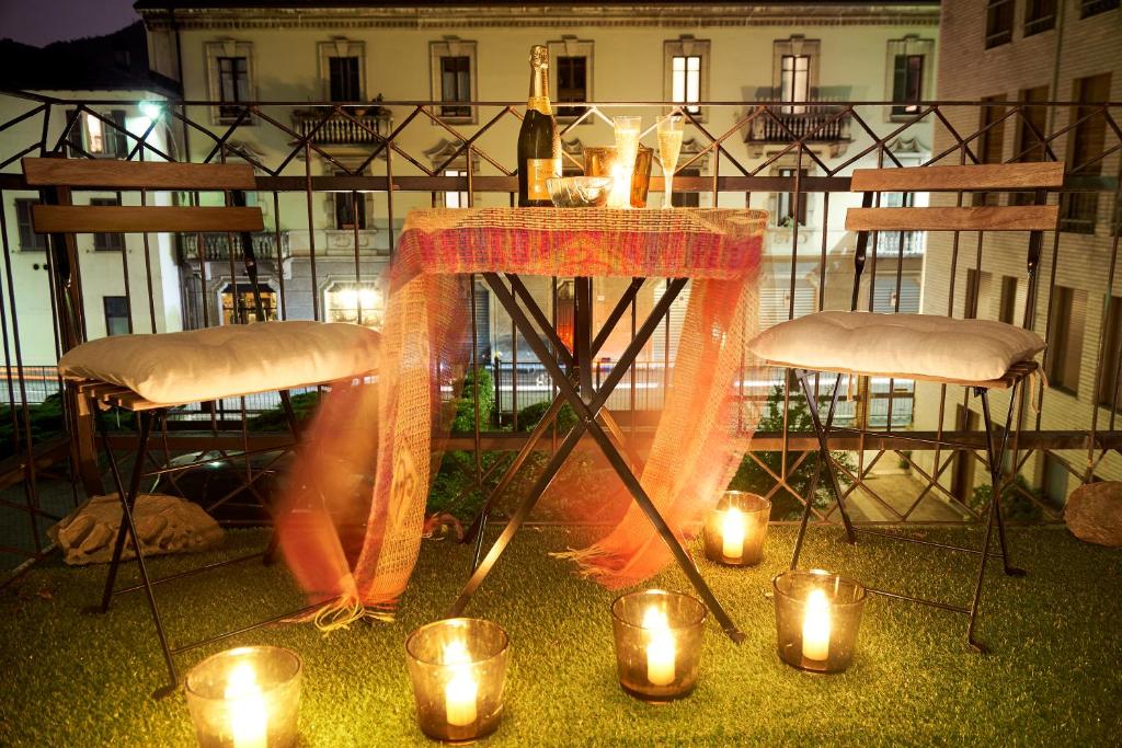 una mesa con velas y luces en el balcón en An Artist's Place, en Como
