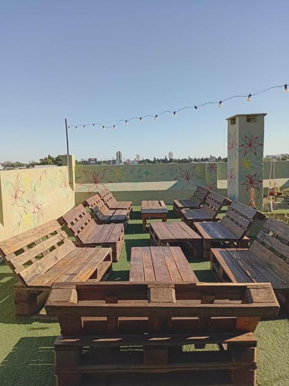 a group of wooden benches sitting in a field at Alojamiento Avellaneda in Rosario