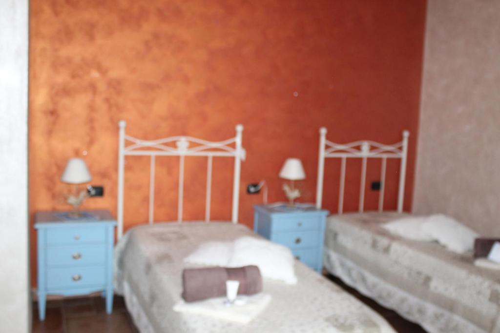 sypialnia z 2 łóżkami i 2 niebieskimi stołami i 2 lampami w obiekcie B&B la Pavoncella w mieście Villamar