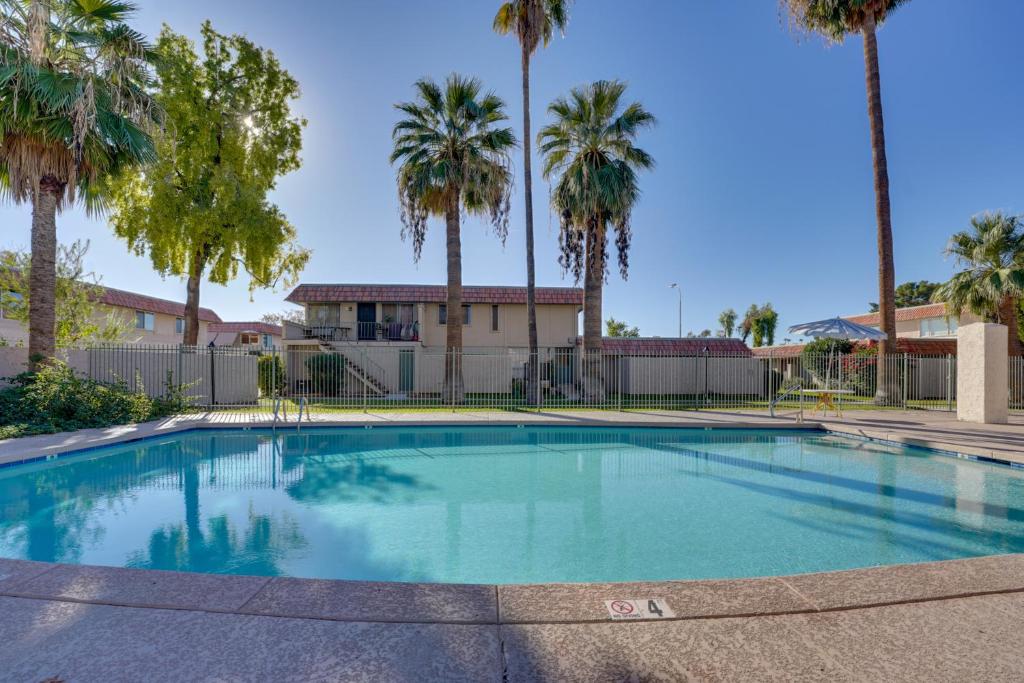 een zwembad met palmbomen en een gebouw bij 9 Mi to Downtown Tempe Condo with Pool Access in Helena
