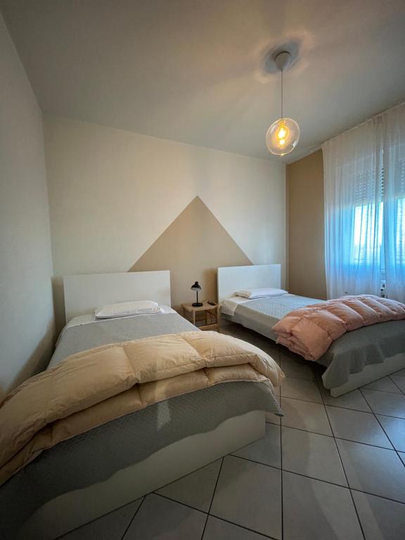 una camera da letto con due letti e una finestra di DooR48 a Novara