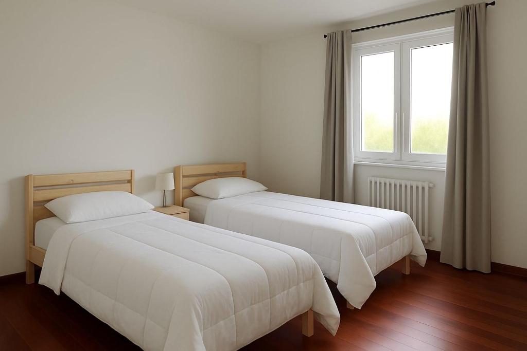 deux lits dans une chambre blanche avec une fenêtre dans l'établissement Rovio Villa lake View & Relax, Lago di Lugano 4guests, à Lugano