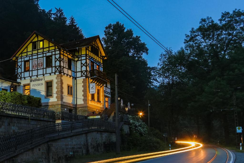 una casa al costado de una carretera por la noche en Hotel Waldhäusel en Bad Schandau