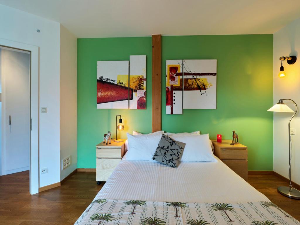 une chambre avec un grand lit aux murs verts dans l'établissement BUDA Lodge 4 Alsace Eurométropole Strasbourg, à Oberhausbergen