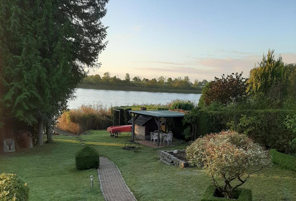 ein Pavillon mit Tisch und Stühlen neben einem See in der Unterkunft Ferienhaus direkt am See in Blankensee
