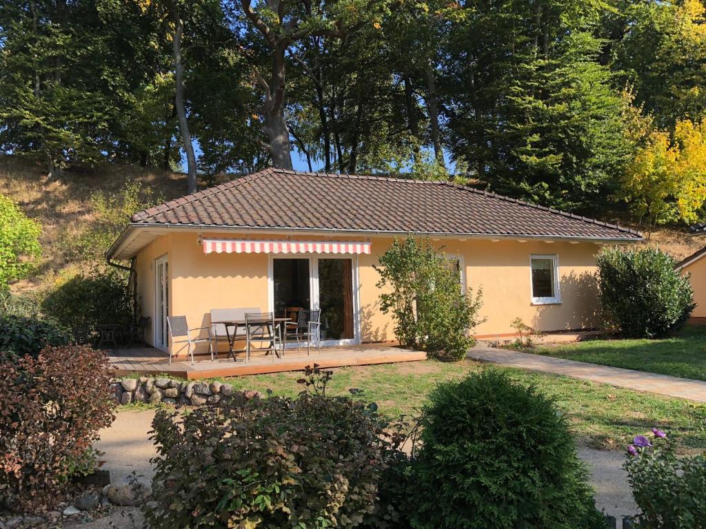 a small yellow house with a table and chairs at Ferienhaus am Plauer See in Lenz