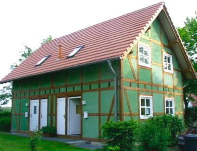 a small green house with a red roof at Ferienhaushälfte Fleesensee in Göhren-Lebbin
