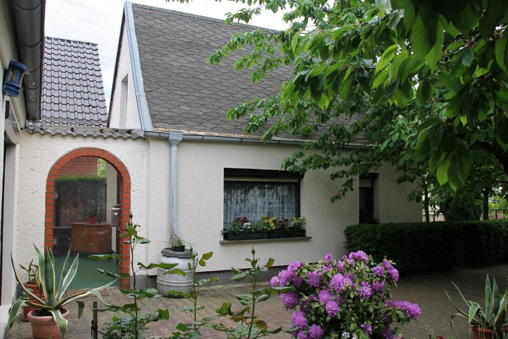 a white house with flowers in a yard at Ferienhaus in Waren Müritz in Waren