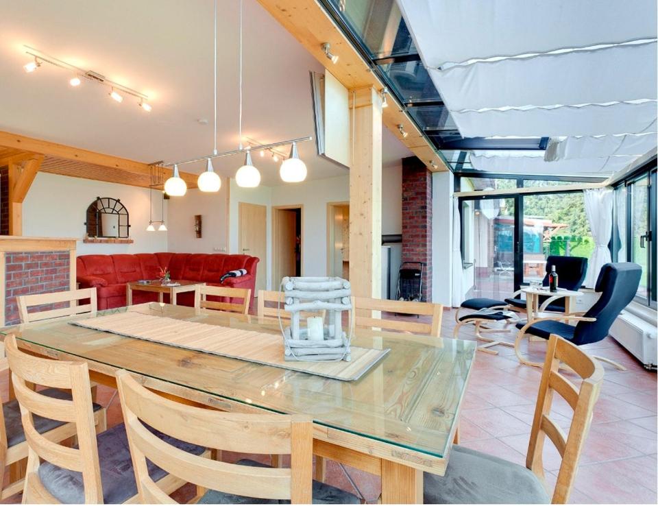 een eetkamer met een glazen tafel en stoelen bij Ferienhaus Krakower See in Serrahn