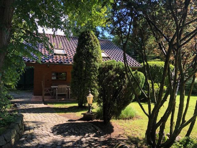 een huis met een grote struik in de tuin bij Blockhaus am Waldrand in Brieselang