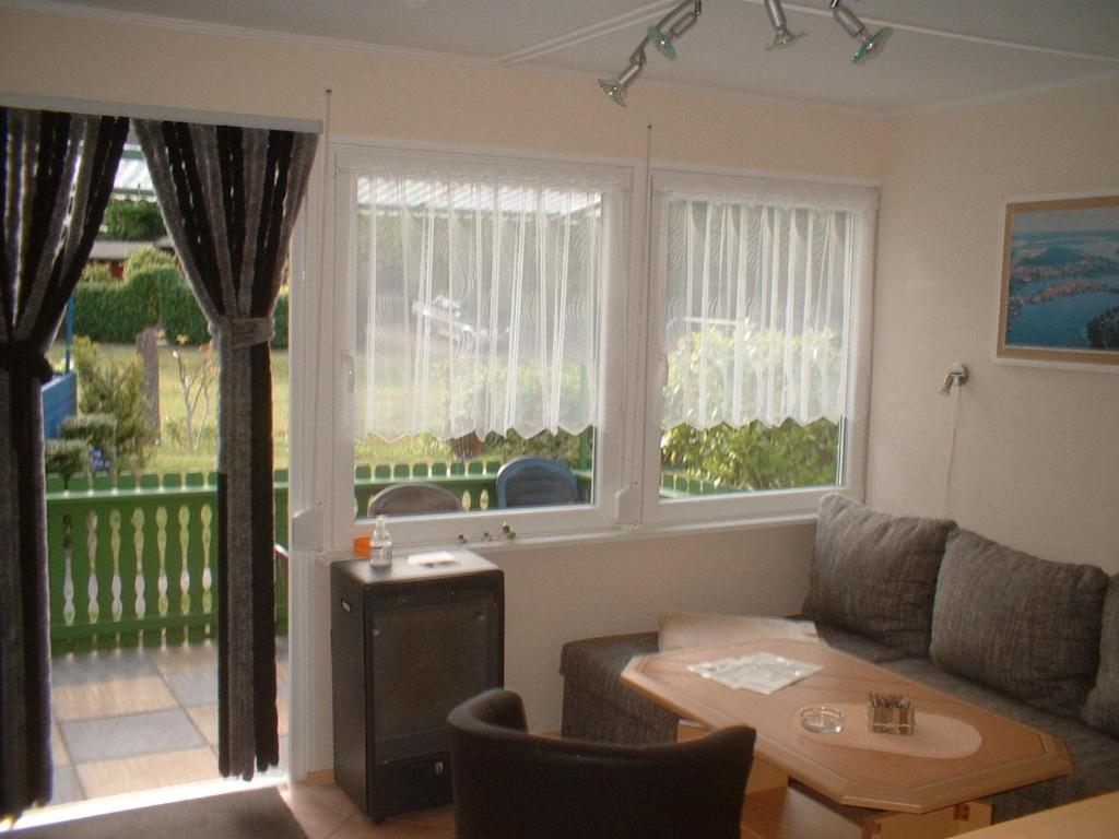 a living room with a couch and a table at Ferienbungalow Fleesensee in Malchow