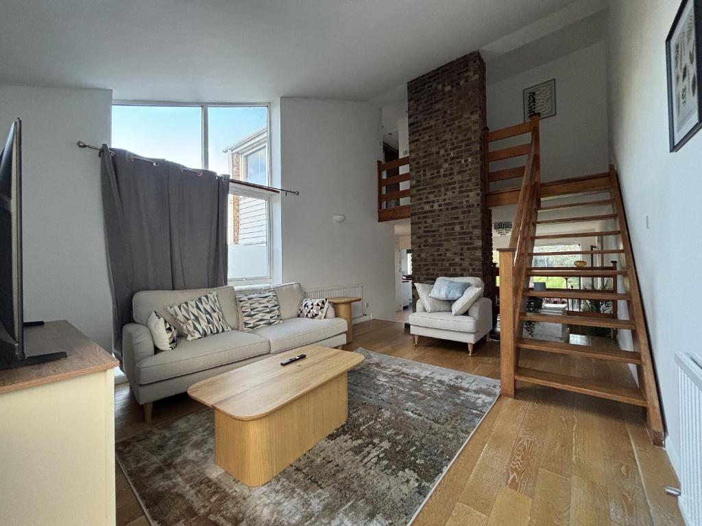 een woonkamer met een bank en een tafel bij Spacious 4-Bed Home in Ascot in Ascot