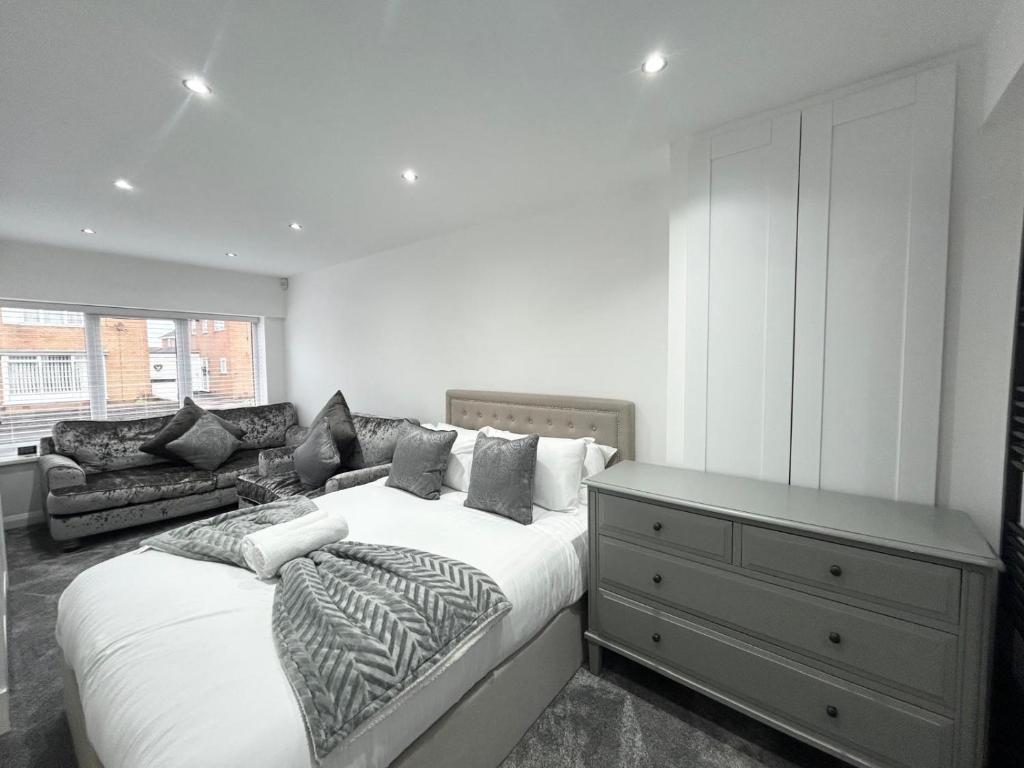 een slaapkamer met een groot bed en een ladekast bij Dalton House - Private Parking in Blackpool