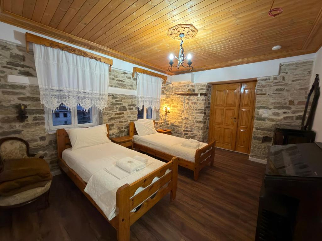 吉诺卡斯特Hotel Drasa的一间卧室，配有两张床和木质天花板