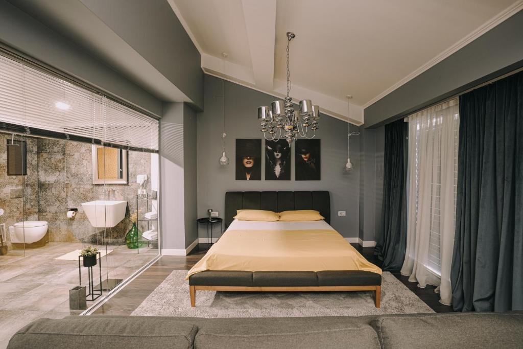 a bedroom with a large bed and a bathroom at VNVP Apartment in Štip