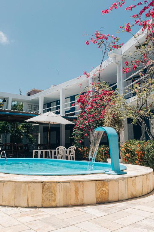a pool with a water fountain in front of a building at Pousada Recanto Porto de Galinhas in Porto De Galinhas