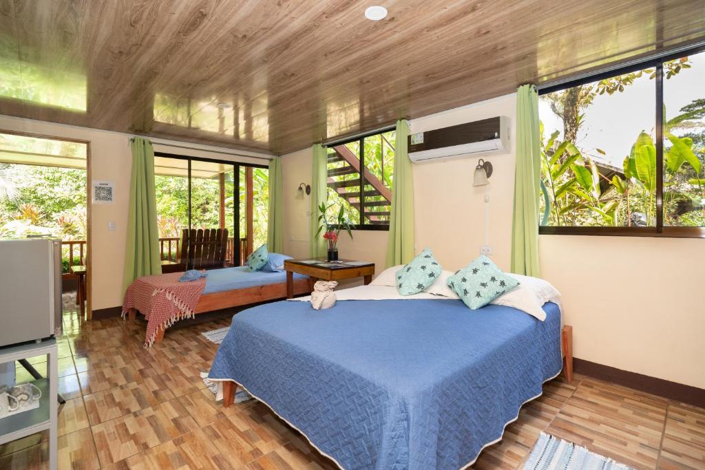a bedroom with a bed in a room with windows at Casa el Tortugo in Drake