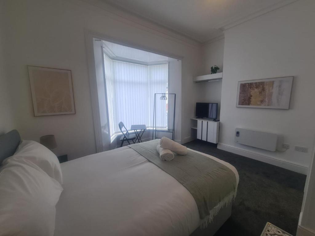 a bedroom with a bed with a teddy bear on it at Modern Studios in Sunderland