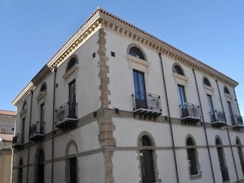 ein großes weißes Gebäude mit Fenstern und Balkonen darauf in der Unterkunft Hotel Palazzo Fortunato in SantʼAgata di Militello
