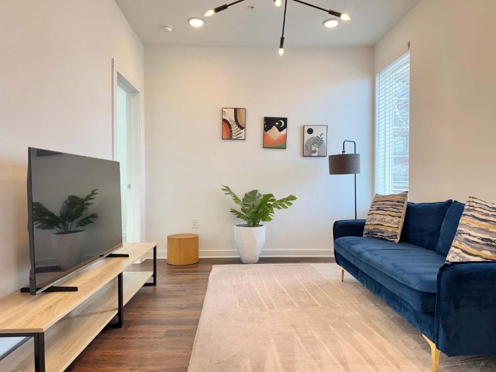 a living room with a blue couch and a tv at New 1B1B Condo in Old Fourth Ward 542Blvd207 in Atlanta