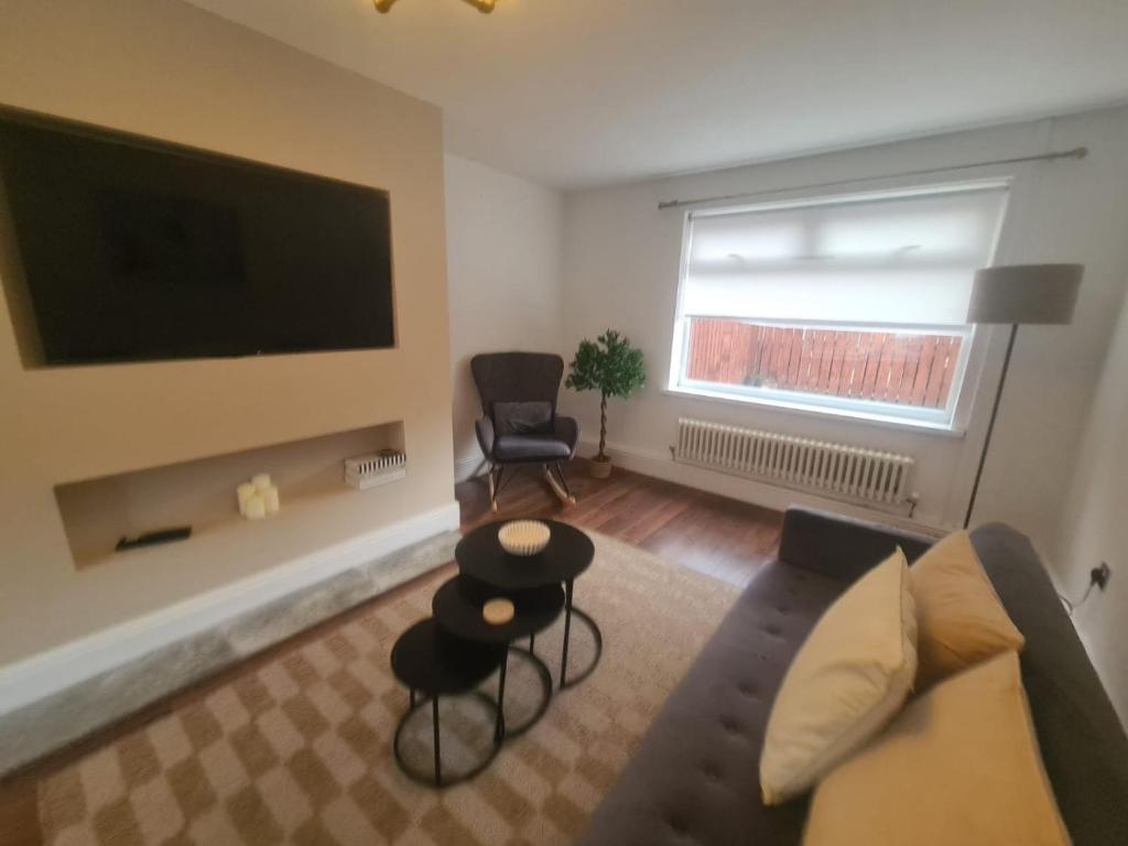 a living room with a couch and a flat screen tv at Stylish 3 bed close to Nissan in Sunderland