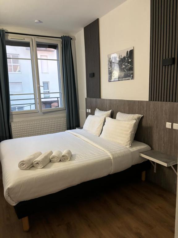 a bedroom with a bed with two pairs of shoes on it at Little Lodge Hôtel in Brest