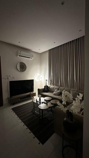 een woonkamer met een bank en een tafel bij شقة بصالة وغرفه نوم in Hafr Al Baten