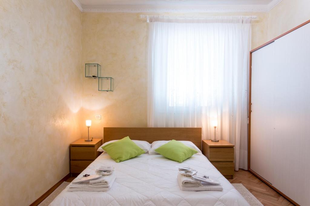 a bedroom with a bed with green pillows and a window at Apartment n3 in City Centre in Rome