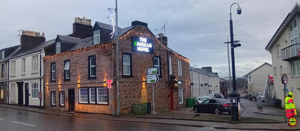 ein Backsteingebäude mit einem Schild auf einer Straße in der Unterkunft Hotel Room in Maybole for Work Travel & Leisure in Maybole