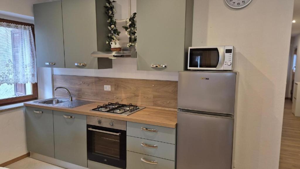 a kitchen with a stainless steel refrigerator and a microwave at Silvia's Home in Calalzo