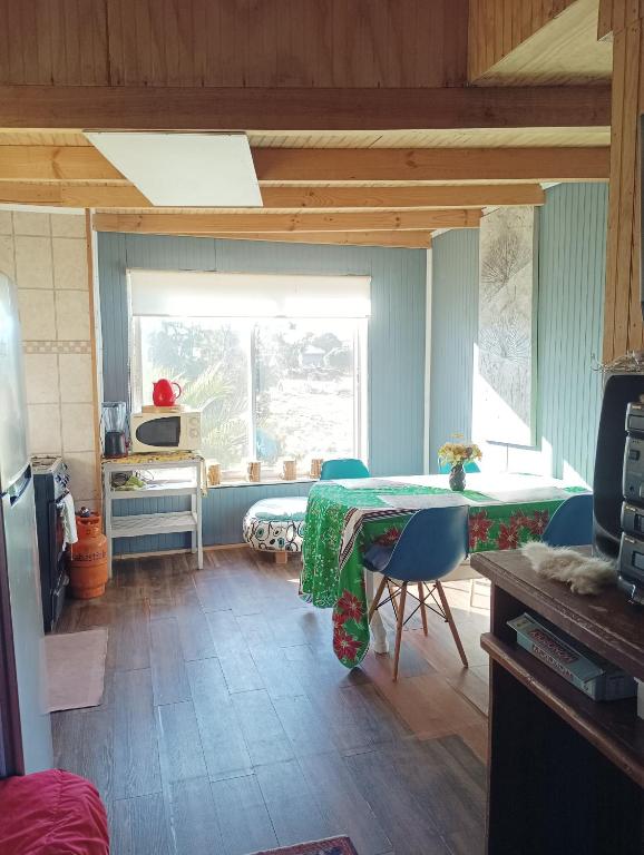 een keuken met een tafel en stoelen in een kamer bij Cabañas Sandra Bucalemu Alto in Bucalemu