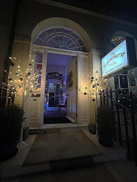 韦茅斯伊甸赫斯特住宿加早餐旅馆的一栋房子的前门，门上挂着灯和招牌。