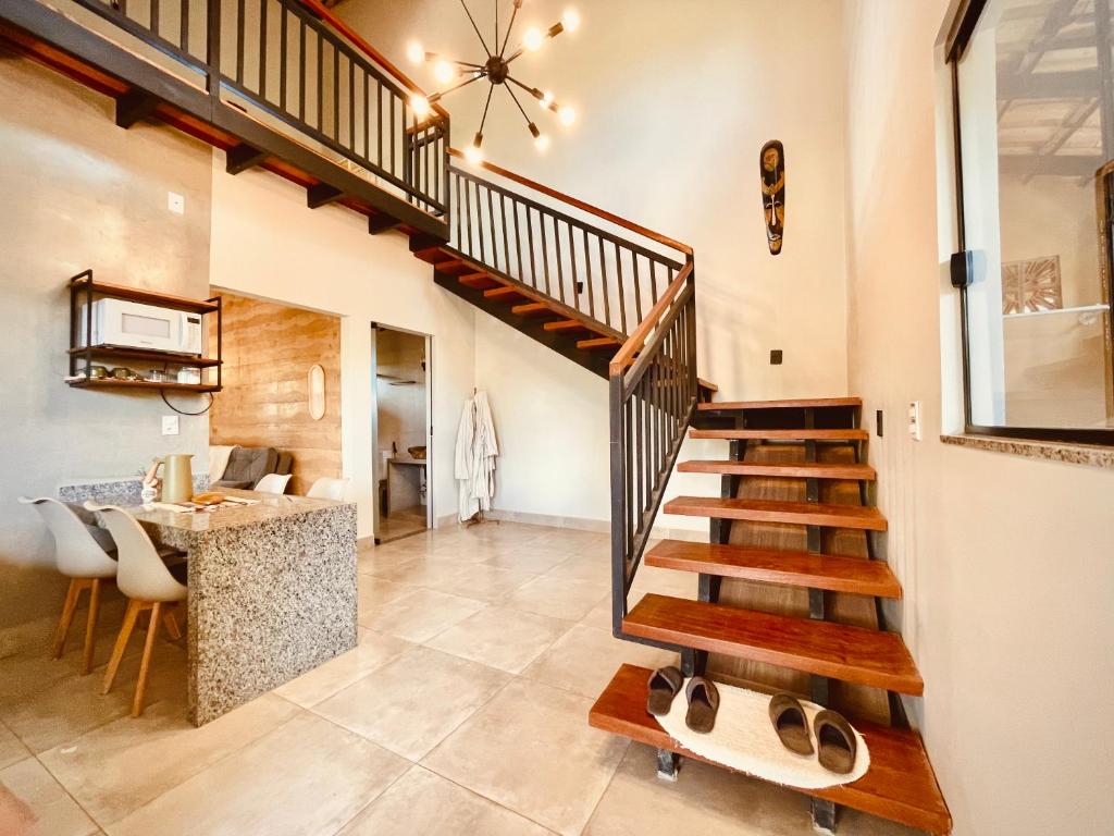 una scala in una stanza con cucina e bancone di Claruá Chalés - Loft Caju - Romântico & Charmoso em Cavalcante Chap dos Veadeiros a Cavalcante