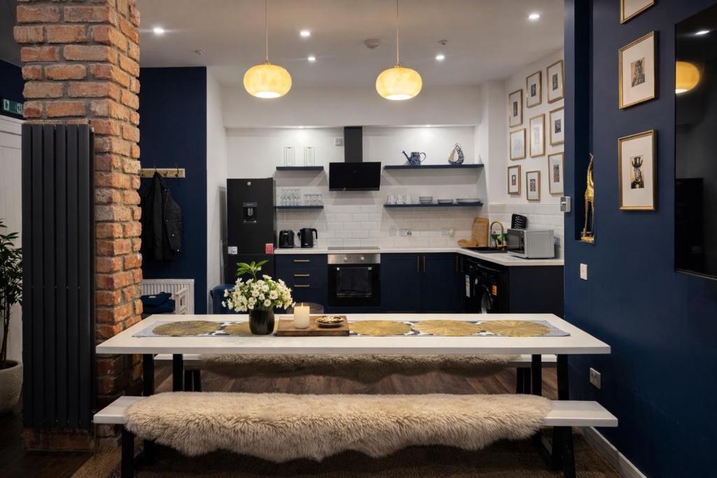a kitchen with a large white table and blue walls at Inbhir Nis City Apartment in Inverness