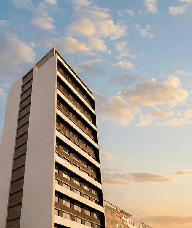un alto edificio blanco contra un cielo nublado en WL Hotel Maputo Executive, en Maputo