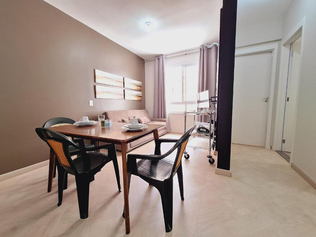 ein Esszimmer mit einem Holztisch und Stühlen in der Unterkunft Centro 15 in Belo Horizonte