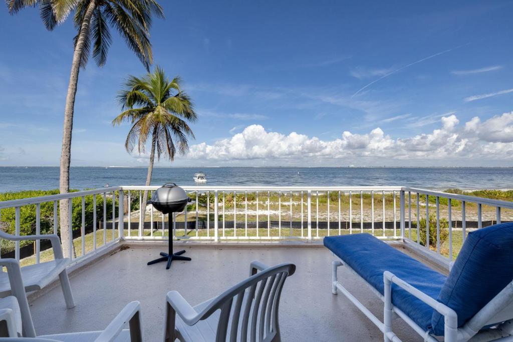 a balcony with chairs and a view of the ocean at Lighthouse Point 228- Stunning Beachside Residence in Sanibel