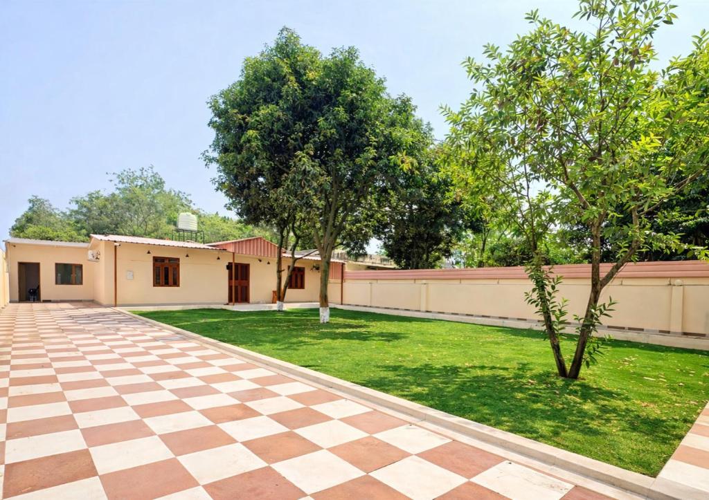 a courtyard of a house with a lawn and trees at A2 Villa by JMD - Peaceful Stay Near Expo Mart in Greater Noida