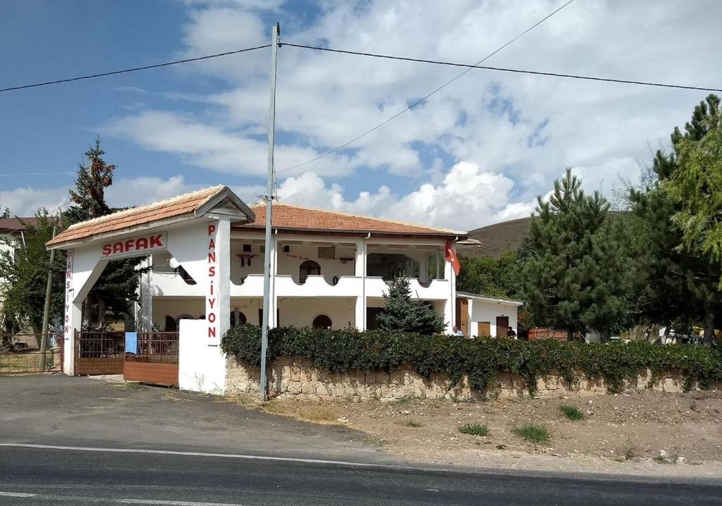 un edificio bianco con un cartello sul lato di una strada di Şafak pansiyon 