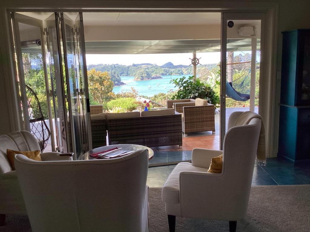 sala de estar con sillas y vistas al agua en Matai Whetū - Stargazer Tutukaka, en Tutukaka