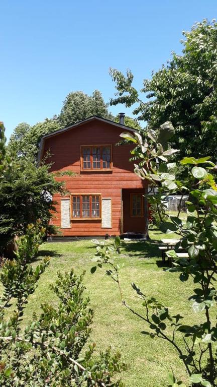 a large wooden house in the middle of a yard at Cabañas el arrayan neltume in Neltume