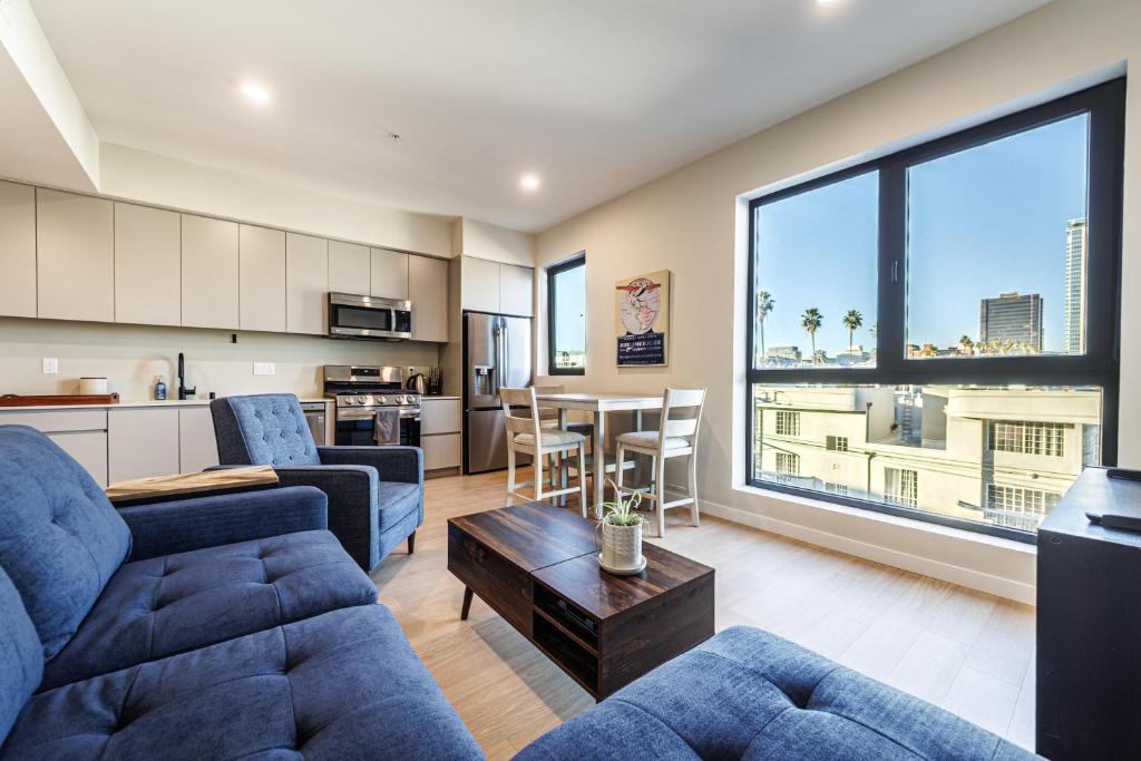 un soggiorno con un divano e un tavolo di Luxury 1BD Condo in LA with Rooftop City Views, Gym & Free Parking a Los Angeles