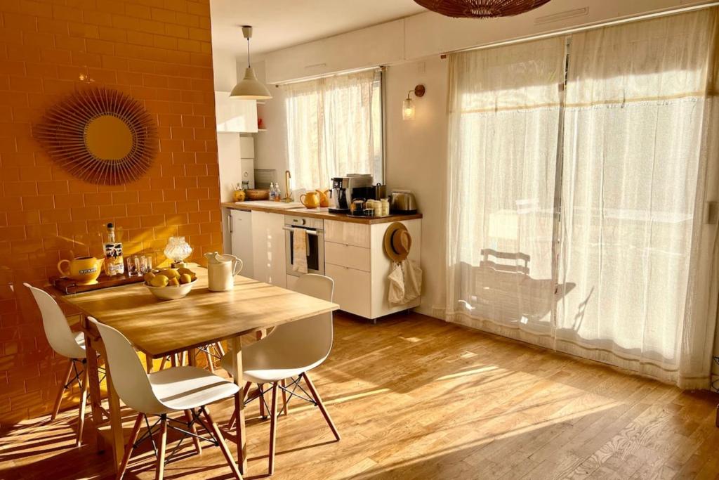 eine Küche mit einem Holztisch und Stühlen in einem Zimmer in der Unterkunft Le Petit Jaune - Studio - Terrasse & Plage Pointe Rouge in Marseille