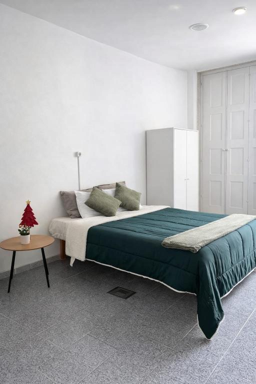 a bedroom with a large bed and a table at Arcanjo Hostel in Braga