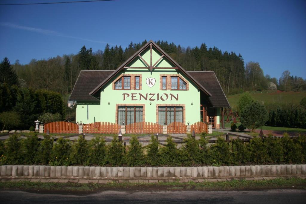 a large white building with a sign on it at Penzion K in Rudník