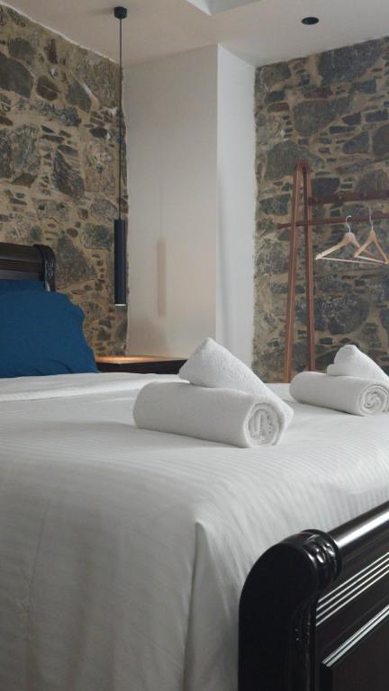 a bedroom with a bed with towels on it at Ephrosinis Cottage in Pedoulas