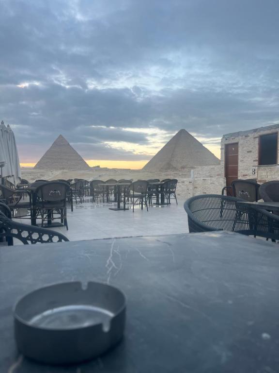 een tafel en stoelen met piramides op de achtergrond bij Middle East pyramids veiw &spa in Caïro
