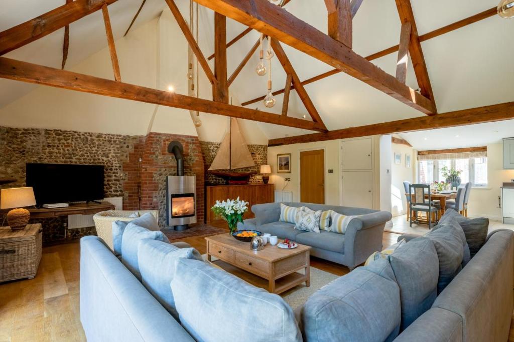 een grote woonkamer met blauwe banken en een open haard bij 4 Bed in Blakeney oc-1948 in Blakeney