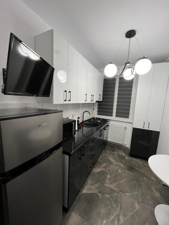 una cucina con frigorifero e una TV in cima di Ideal House Rent a Petroşani